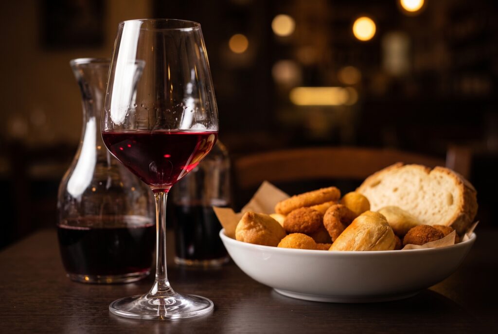Vino rosso della casa in calice e caraffa